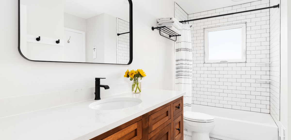 modern farmhouse bathroom with dark oak cabinets, black fixtures, and bright light