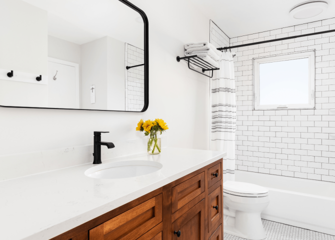 modern farmhouse bathroom with dark oak cabinets, black fixtures, and bright light