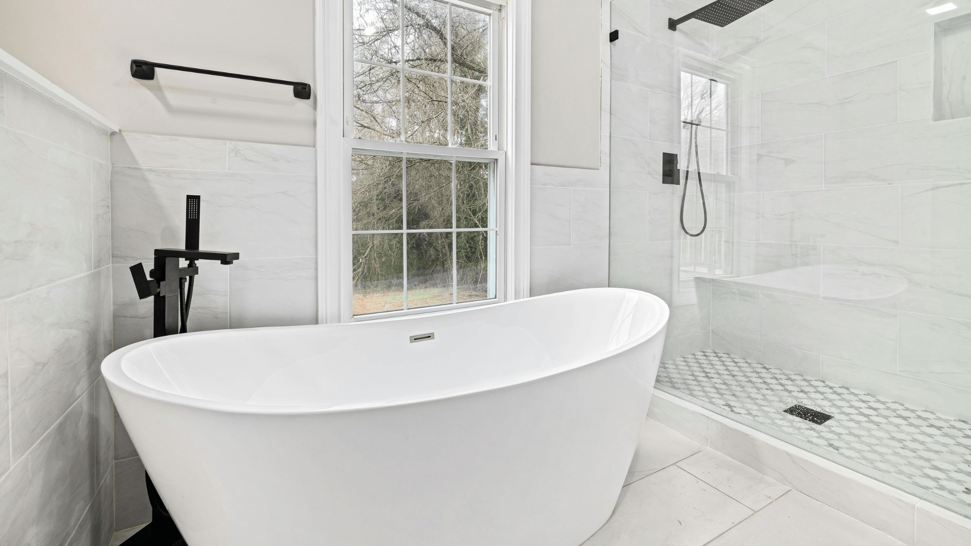 modern bathroom with clean white walls, black fixtures, and a white soaking tub